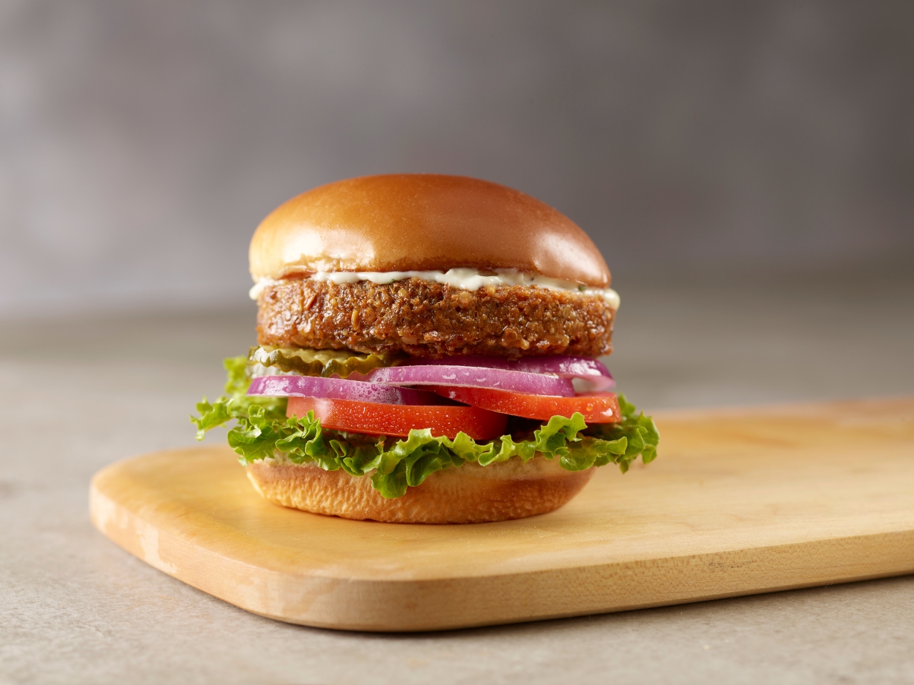 A stacked burger with lettuce, tomato, red onion, pickles, and a juicy veggie patty even a carnivore would approve of.