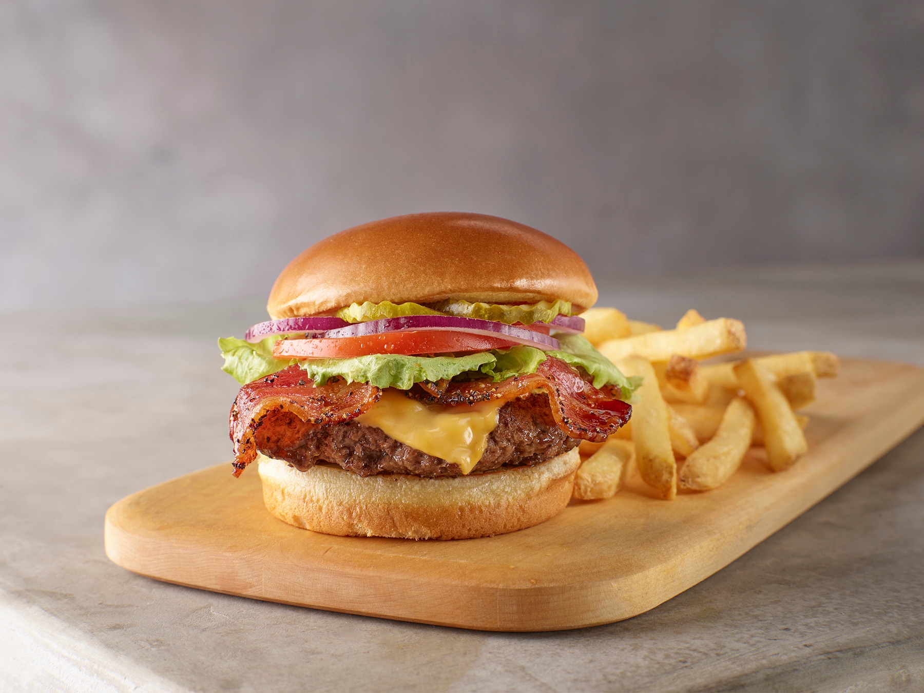 A beef patty topped with bacon, American cheese, lettuce, tomato, red onion, and pickles. Served on a crisp, pillowy bun.