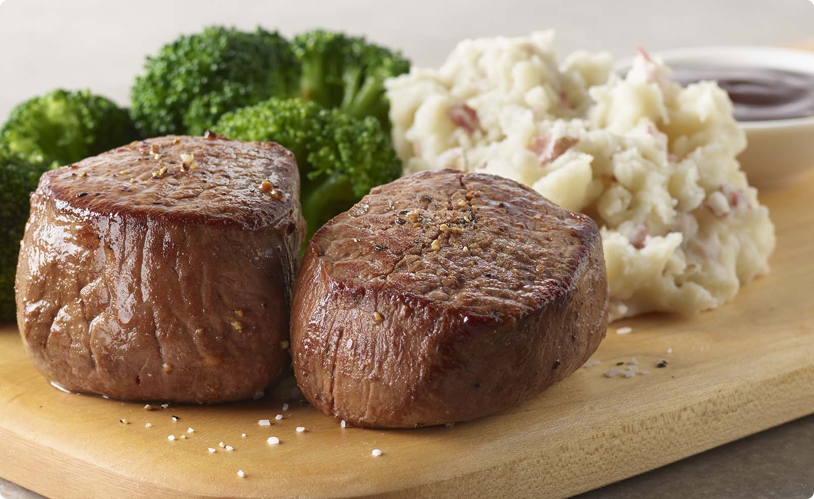 Two 4oz. golden brown filet mignon medallions glistening with red wine sauce. Served with broccoli and mashed potatoes.